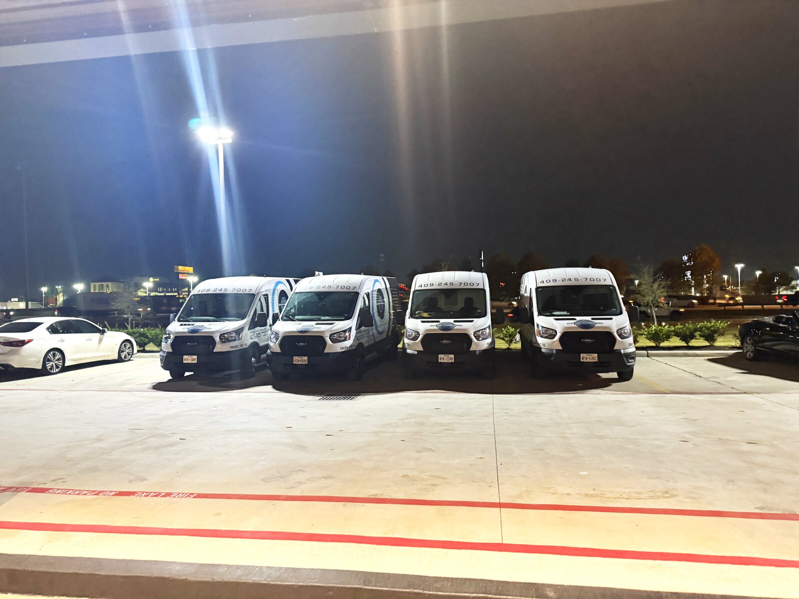 The New Gen Plumbing fleet of four branded service vans parked together in Spring, TX